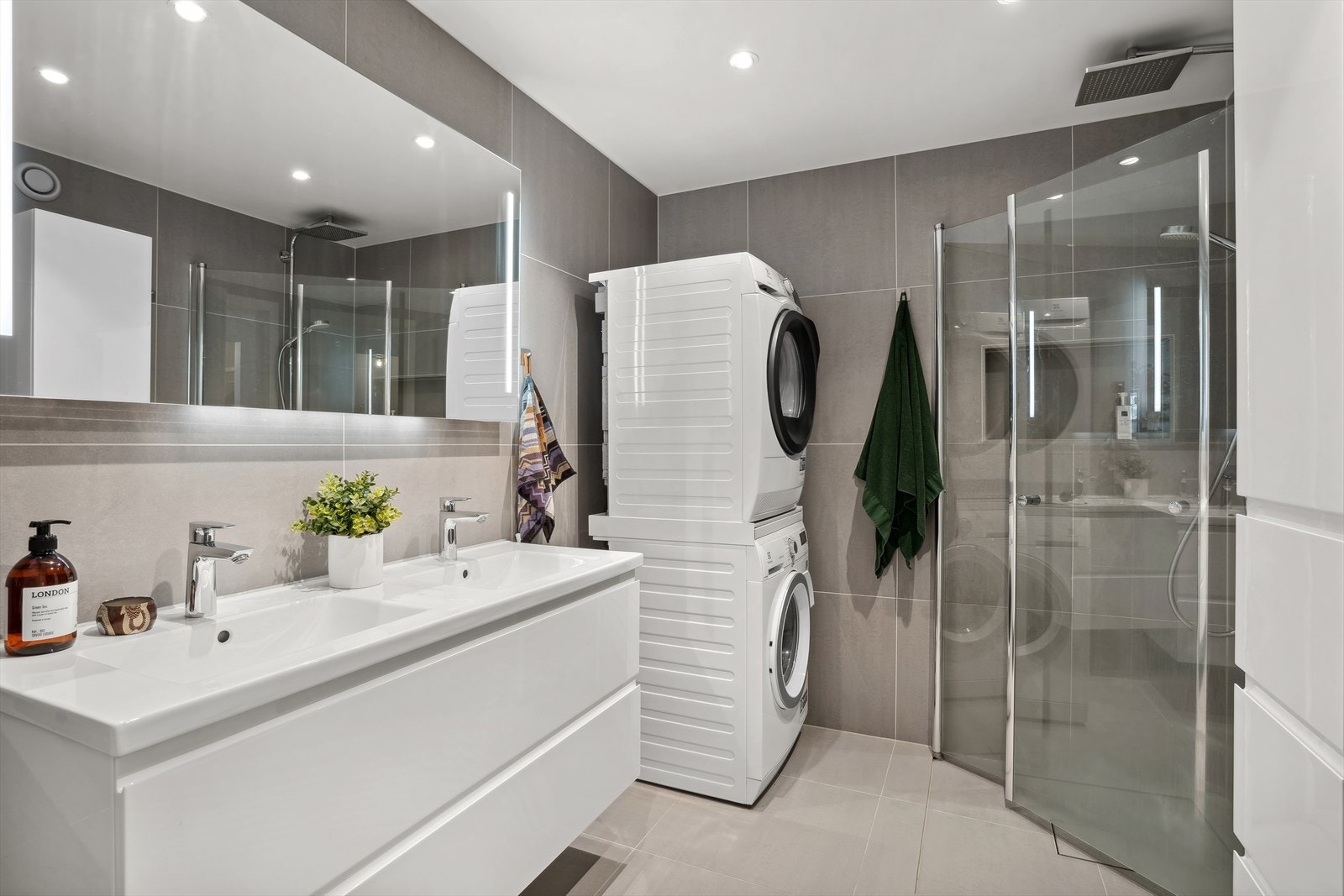 Badet er utstyrt med lekre fliser, opplegg for vaskemaskin og dusj med innfellbare dusjvegger Galleribilde