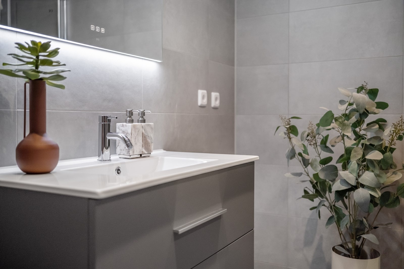 Innredningen bestående av servant, vegghengt toalett og dusjhjørne. Galleribilde