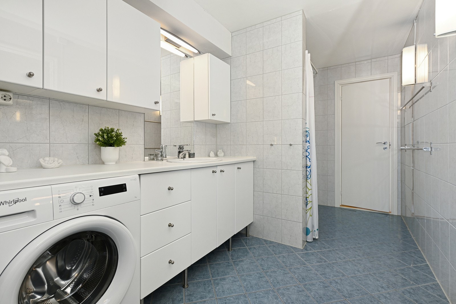 Badet er innredet med nedfelt servant, gulvfestet toalett og dusjnisje. Det er opplegg til vaskemaskin og plass til tørketrommel. Galleribilde