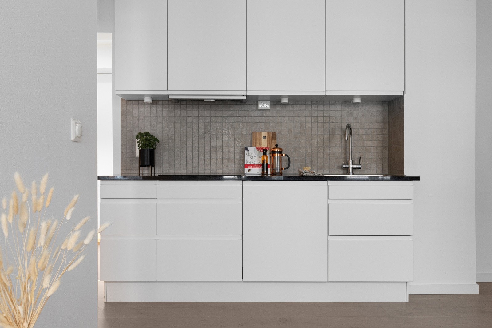 Tidløs kjøkkeninnredning med oppbevaringsmuligheter i over- og underskap. Galleribilde