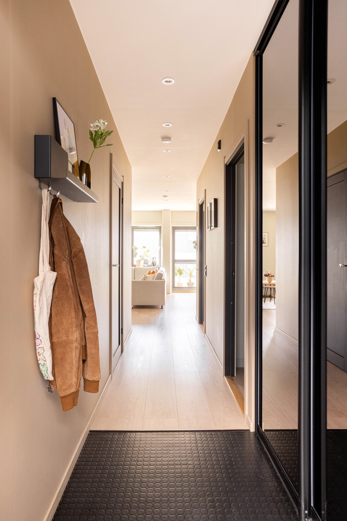 Pent inngangsparti med praktisk flis-belegg på gulv og innbygget skyvedørsgarderobe med speilfronter. Galleribilde