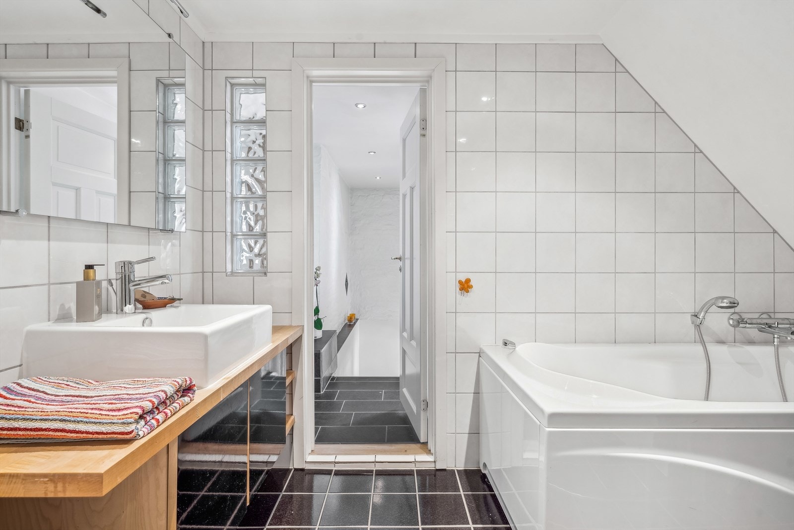 Badet er stort og lyst med downlights i himling. Hvite fliser på vegg og mørkere fliser på gulvet gir en fin kontrast til hverandre. Hulltaking er foretatt uten å påvise unormale forhold. Galleribilde