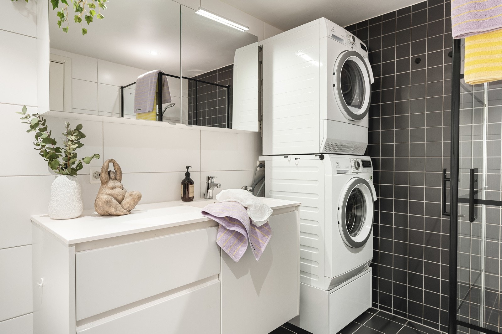 Baderomsinnredning med gode oppbevaringsmuligheter og overskap med speil og belysning. Galleribilde