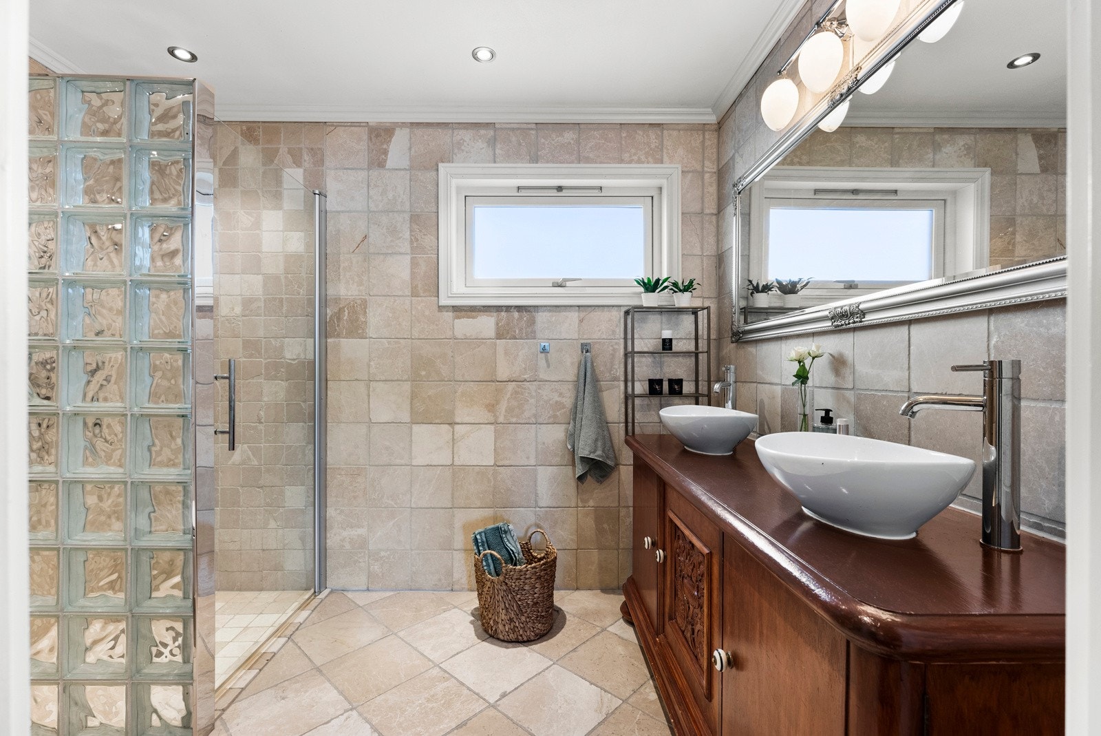 Det ene badet ligger i første etasje og var nytt i 2013. Rommet har rustikke, sandfargede fliser på vegger og gulv, downlights og vannbåren gulvvarme Galleribilde