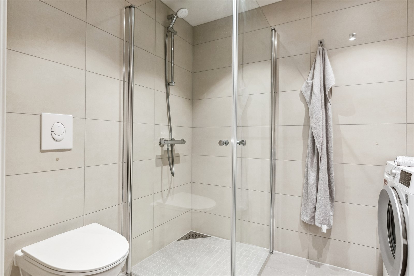 Et vegghengt toalett og dusjhjørne med rette, innfellbare glassdører finnes også på badet. Galleribilde