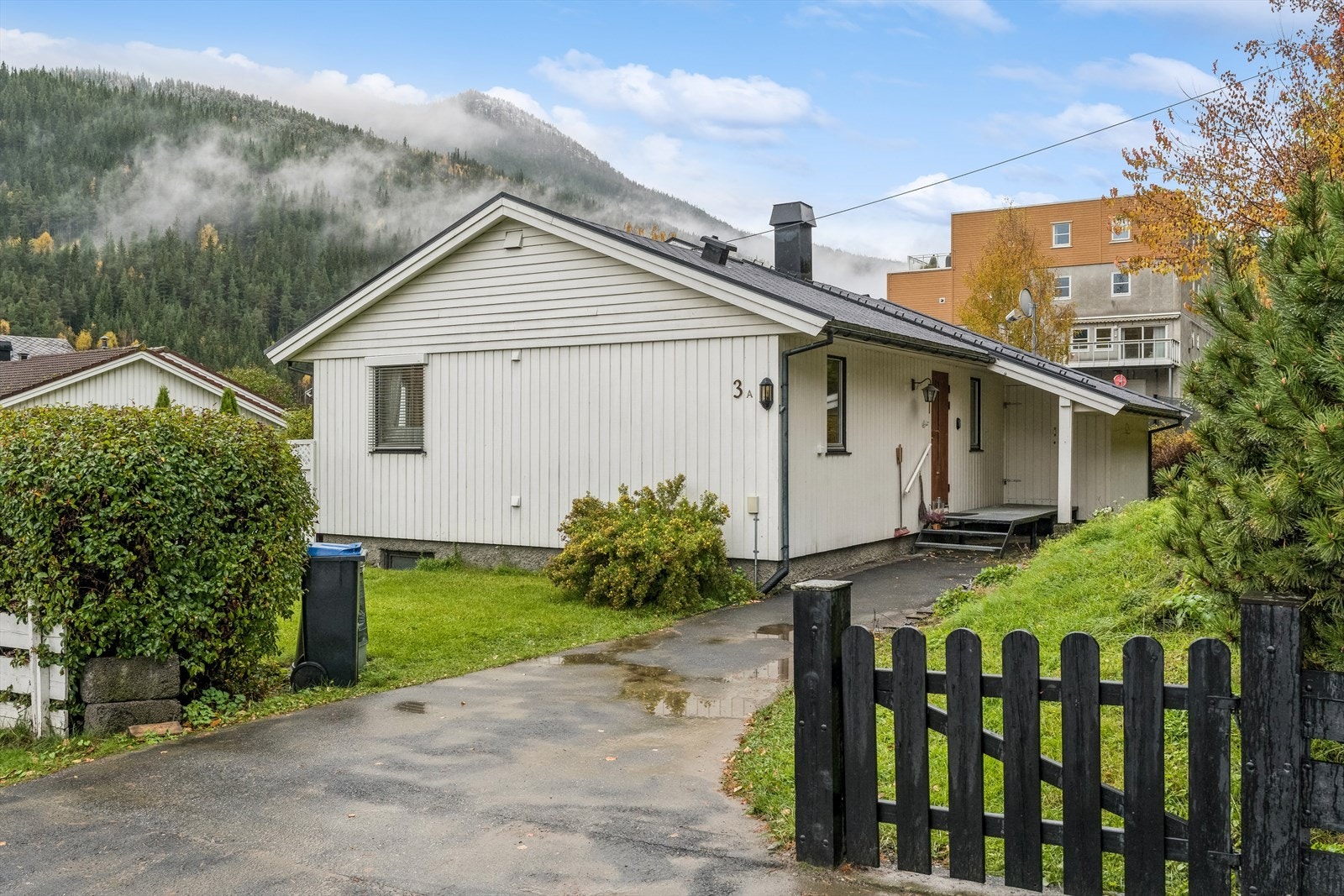 Ligger på tilnærmet flat eiertomt som er pent opparbeidet med plan/grasmark, bed og busker. Ellers er det støttemur i naturstein og asfaltert innkjørsel. Galleribilde