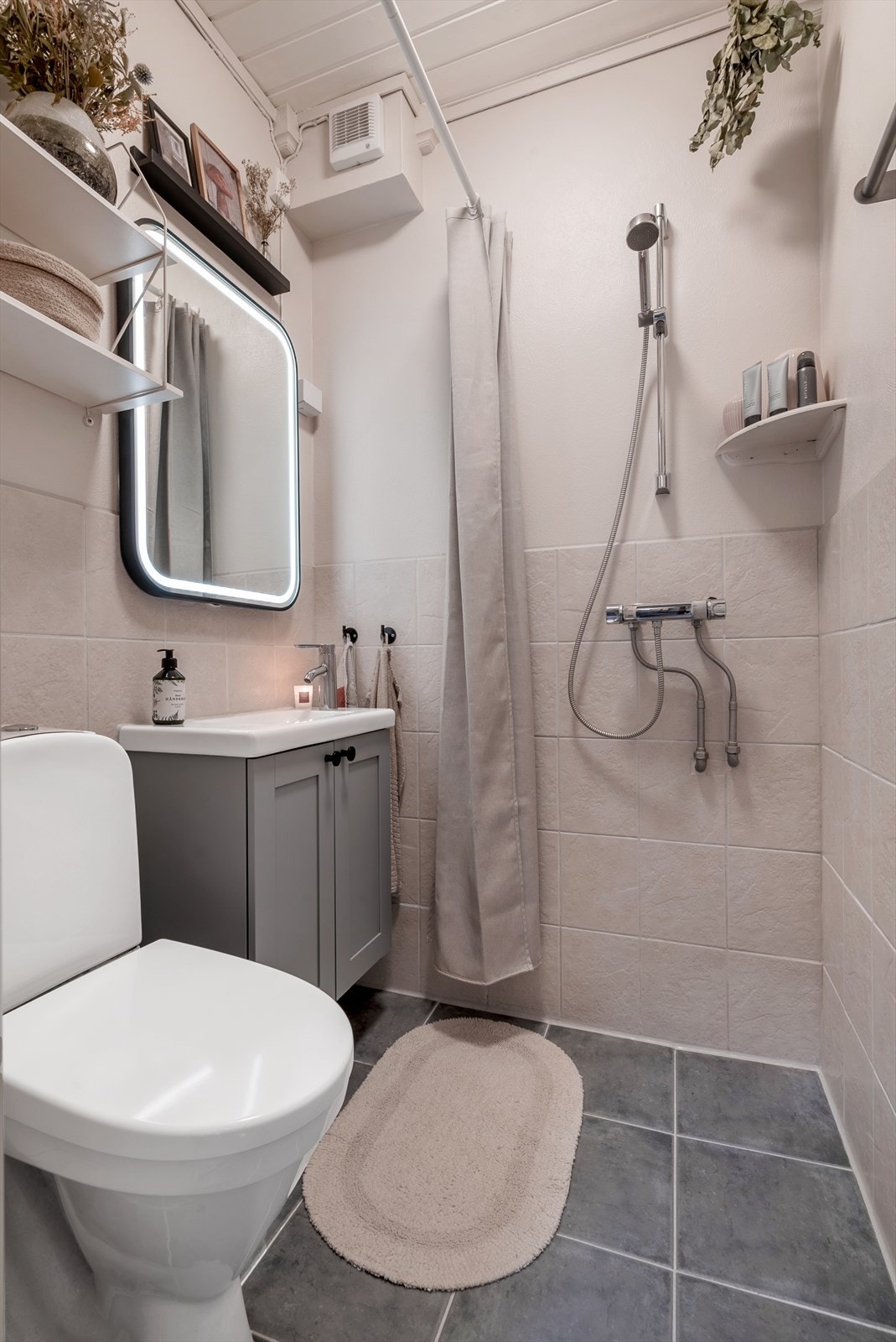 Her får du moderne baderomsinnredning, toalett og praktisk dusjhjørne. Galleribilde