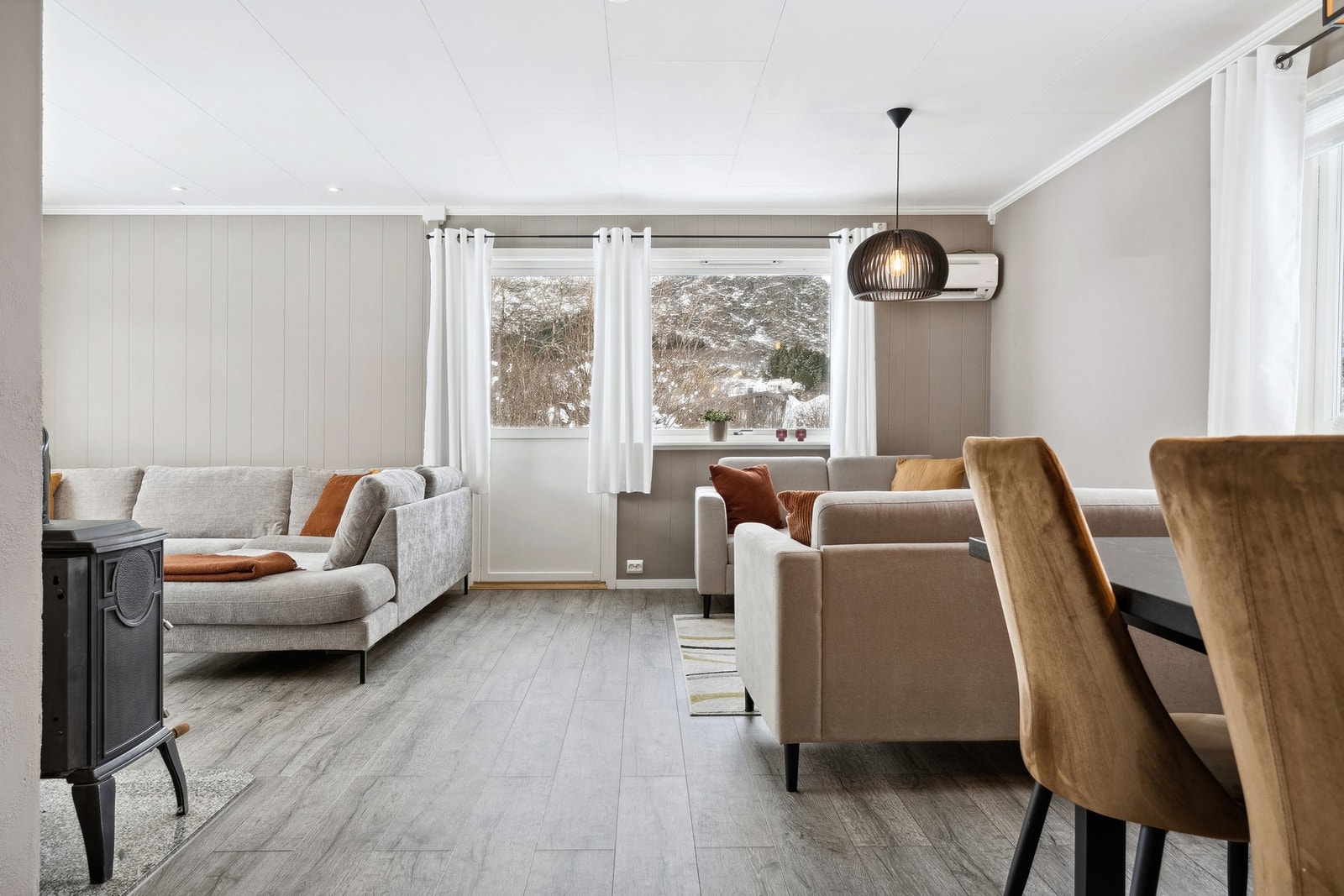 Stuen har en koselig vedovn, som man vil nyte godt av på vinterhalvåret, samt utgang til terrassen og hagen. Galleribilde
