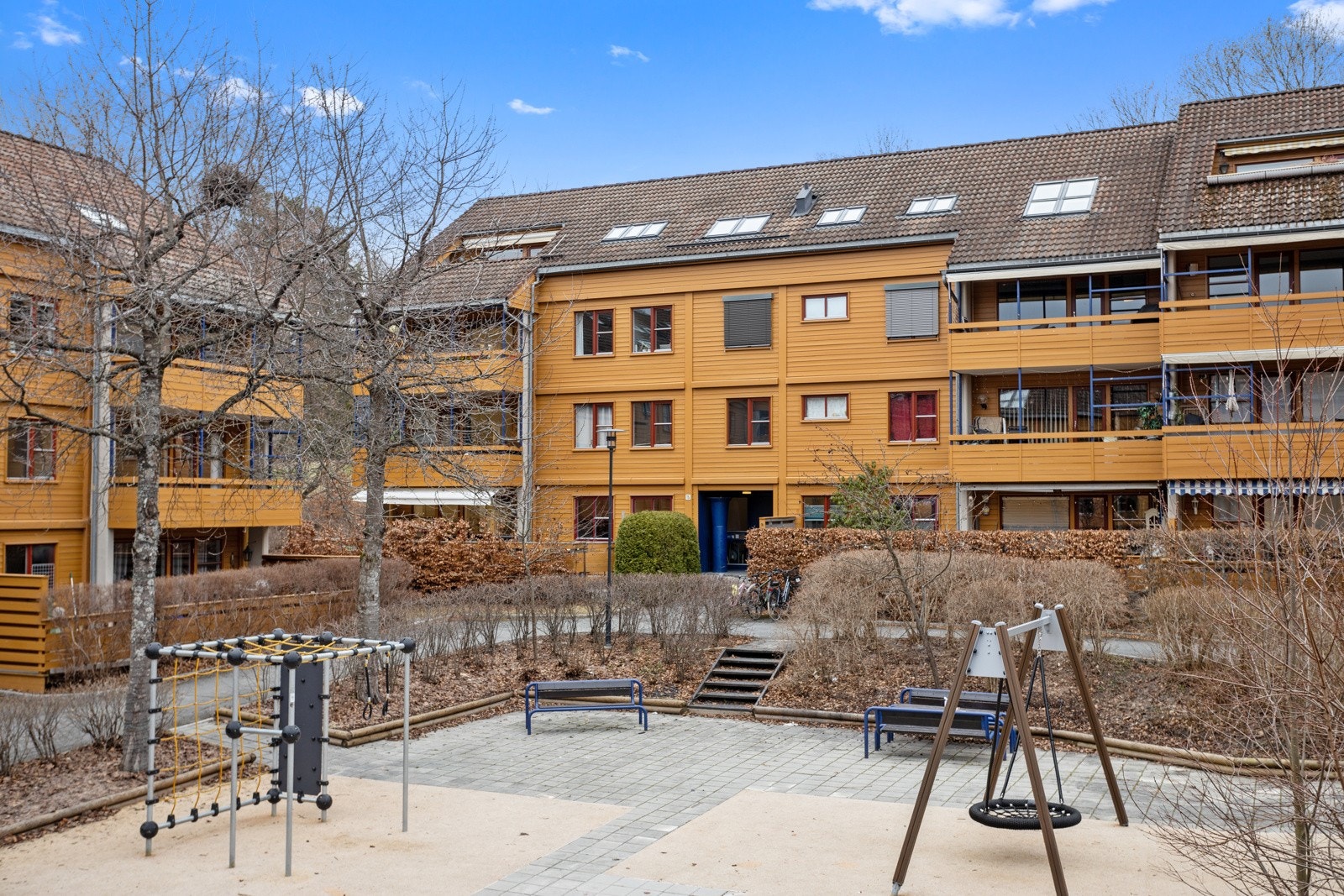 Byggene i Nedre Silkestrå omkranser hyggelige leketun med sittegrupper og lekeapparater. Galleribilde