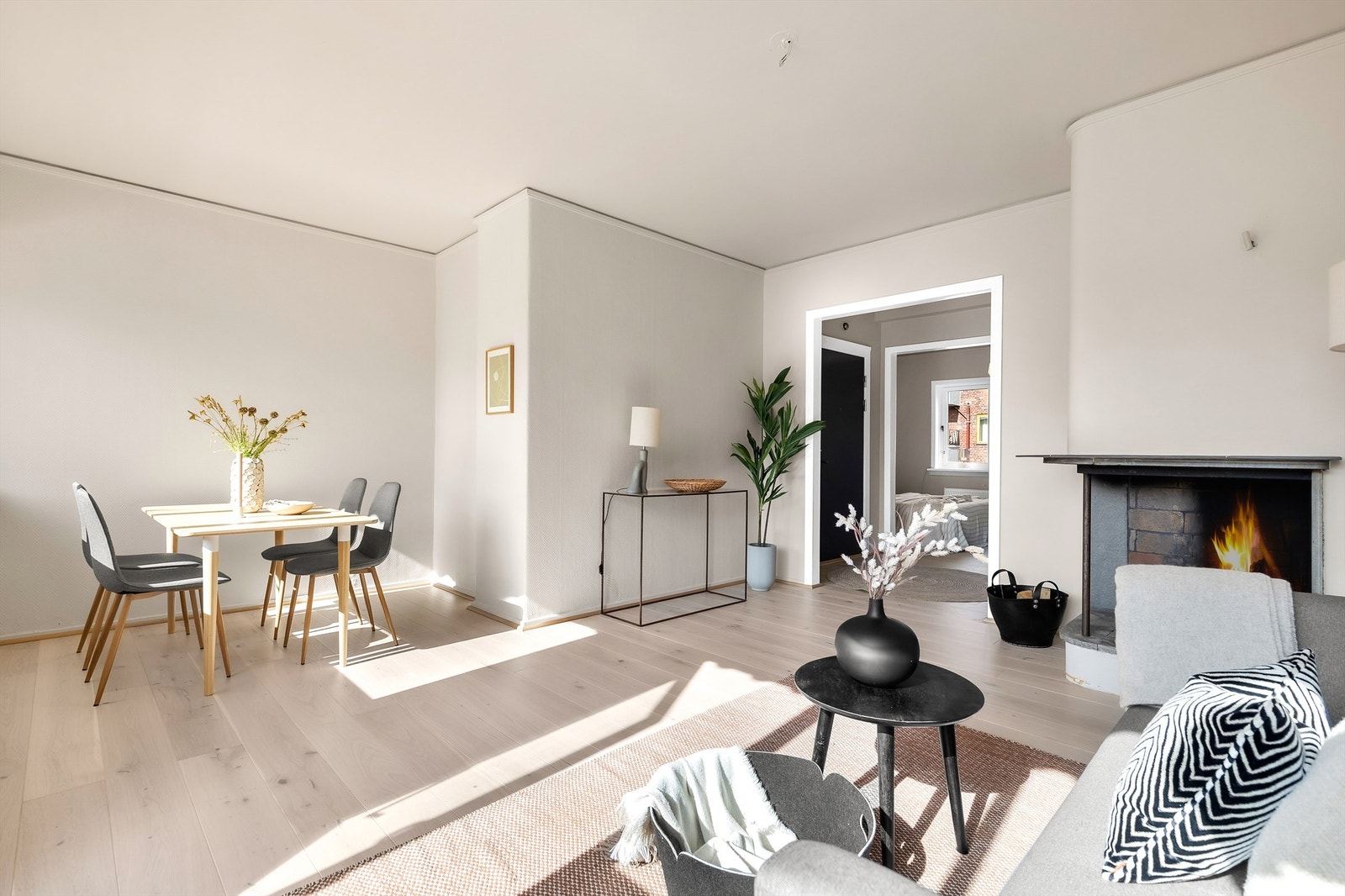 Rommet deles naturlig inn i to soner. Foran peisen har du plass til sofagruppe og i andre enden av rommet er spisestuen. Flammer er redigert inn av fotograf. Galleribilde