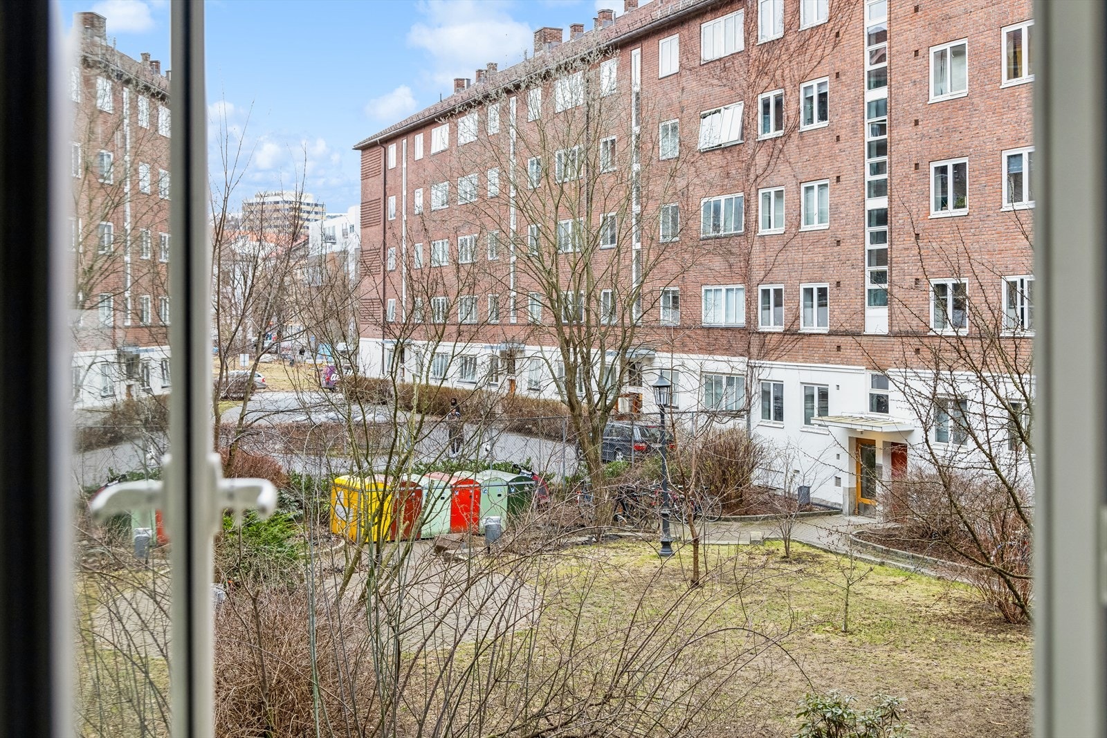 Felles lukket bakgård som er pent opparbeidet med sten belagte passasjer, gressplen, trær og diverse beplantning. Galleribilde