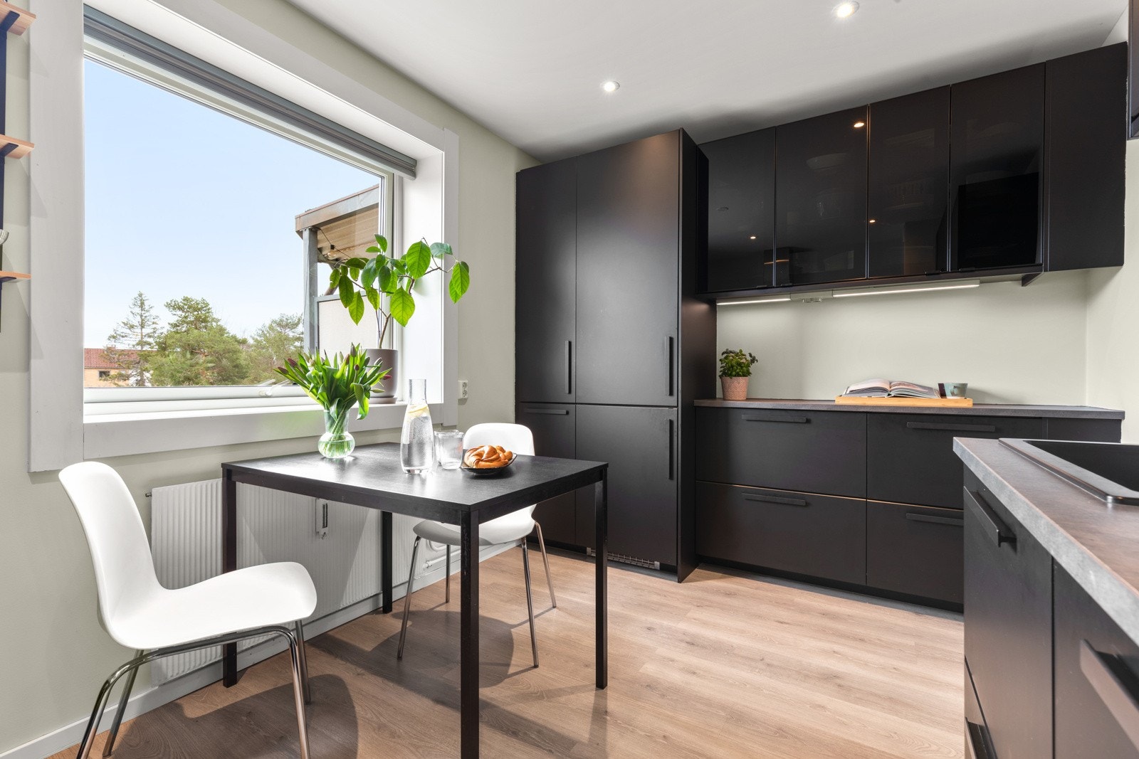 Videre er kjøkkenet utstyrt med integrerte hvitevarer som oppvaskmaskin, kjøl-/fryseskap, stekeovn og induksjonstopp, samt kullfilterventilator, komfyrvakt, benkestikk og god arbeidsbelysning. Galleribilde