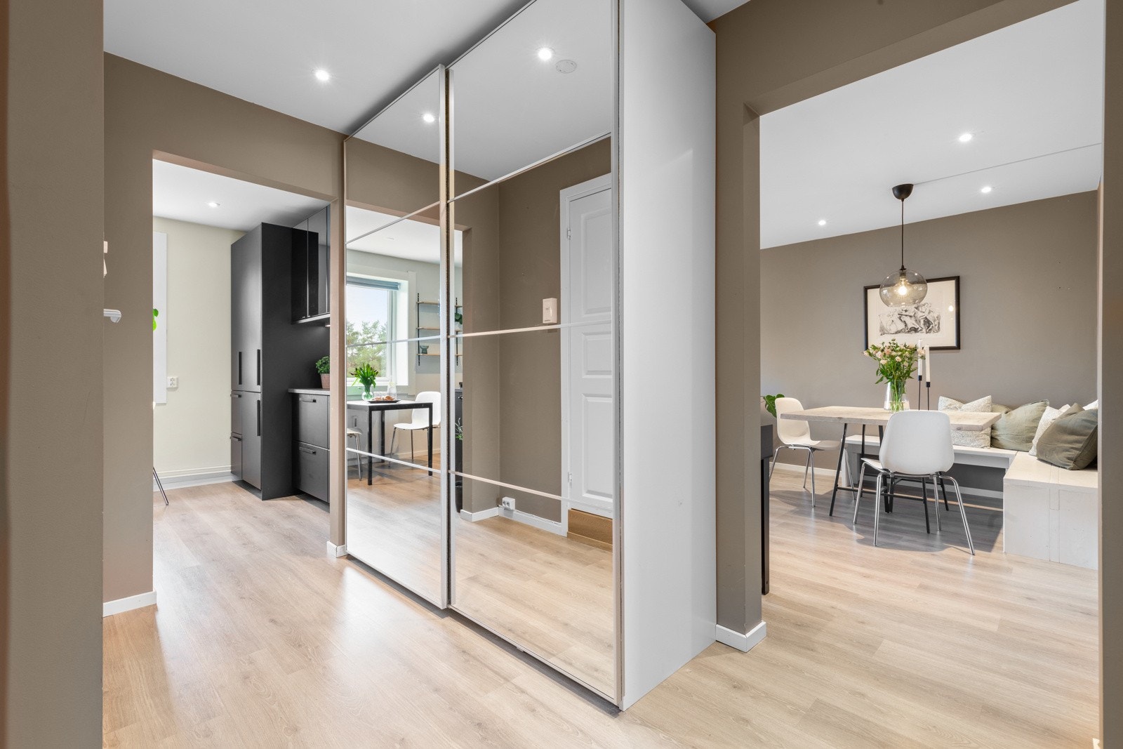 Vel inne blir du møtte av en lys og pen entré. Yttertøy, sko og utstyr ryddes enkelt bort i en takhøy skyvedørsgarderobe med speilfronter. Galleribilde