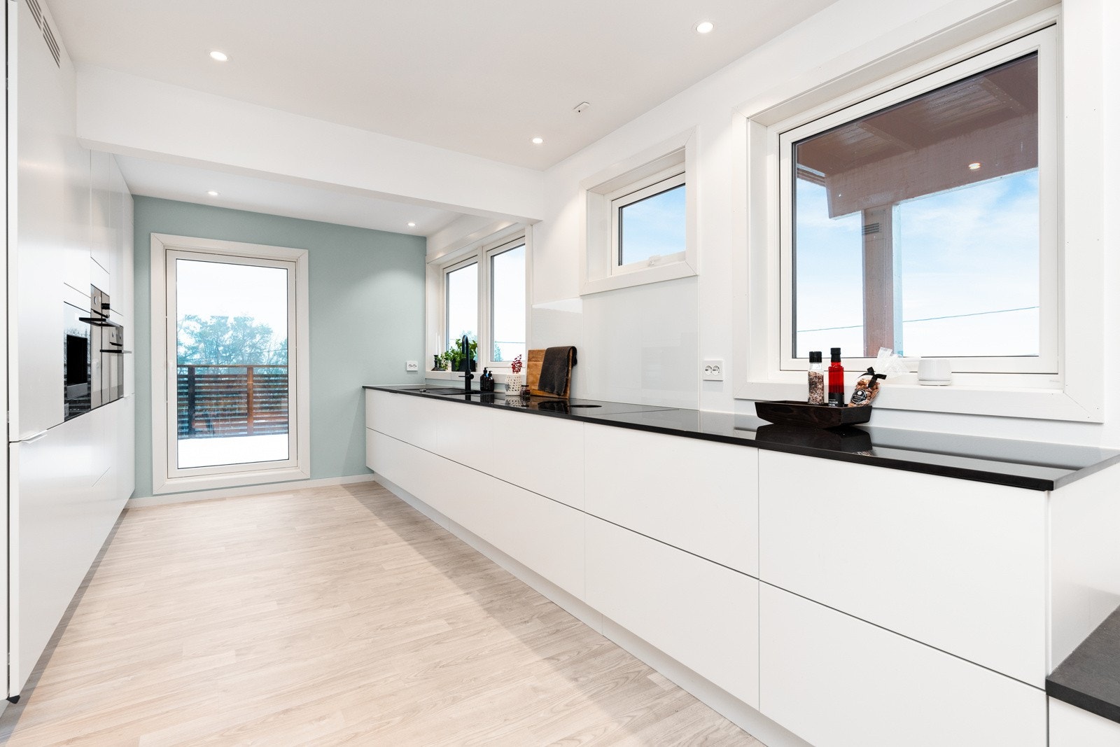 Lyst og innbydende kjøkken med utgang til stor terrasse med utsikt Galleribilde