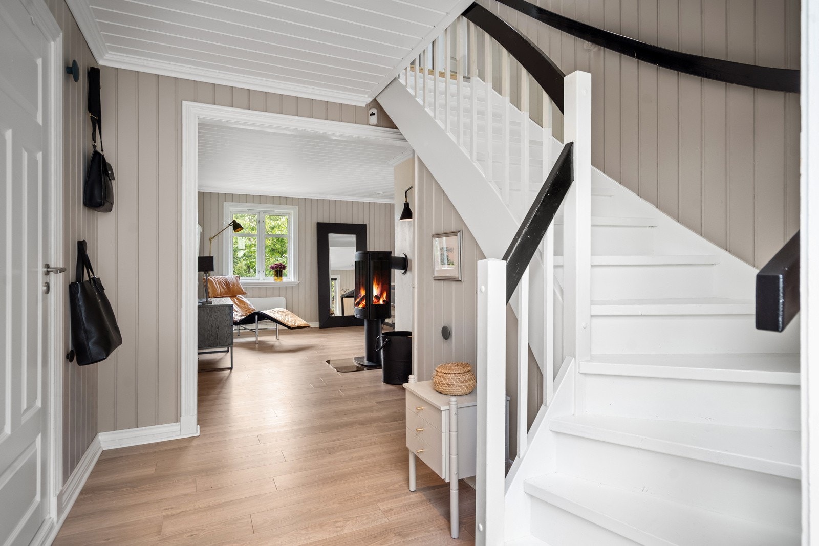 Man kommer inn i en romslig hall med praktisk vaskerom/dusjbad. Videre er det en stor stue med 2 peiser og utgang til meget usjenert og lun terrasse. Galleribilde