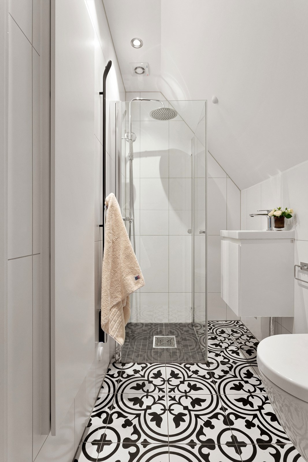 Badet i loftsetasjen er også fra 2018 med dokumentert utførelse. Badet er utstyrt med vegghengt wc, servant med skap under og dusj i hjørne med innadslående dører. Galleribilde