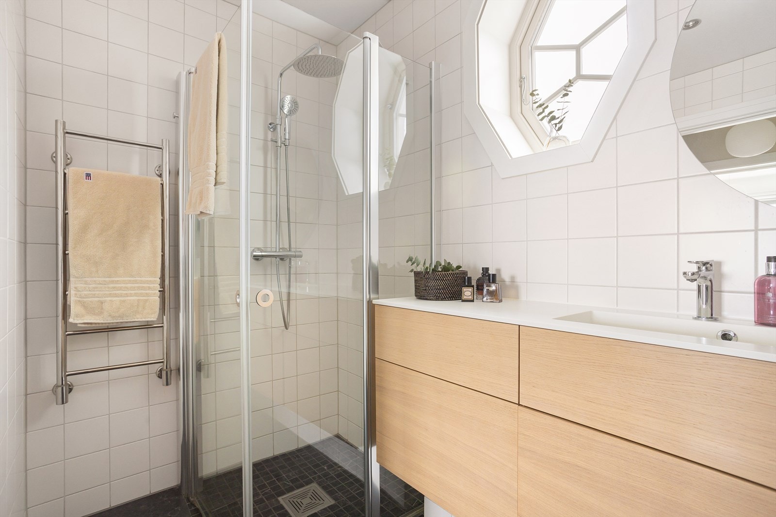 Badet er utstyrt med vegghengt wc, helstøpt Corian servant med skuffer under og dusj i hjørne med innadslående dører. Galleribilde