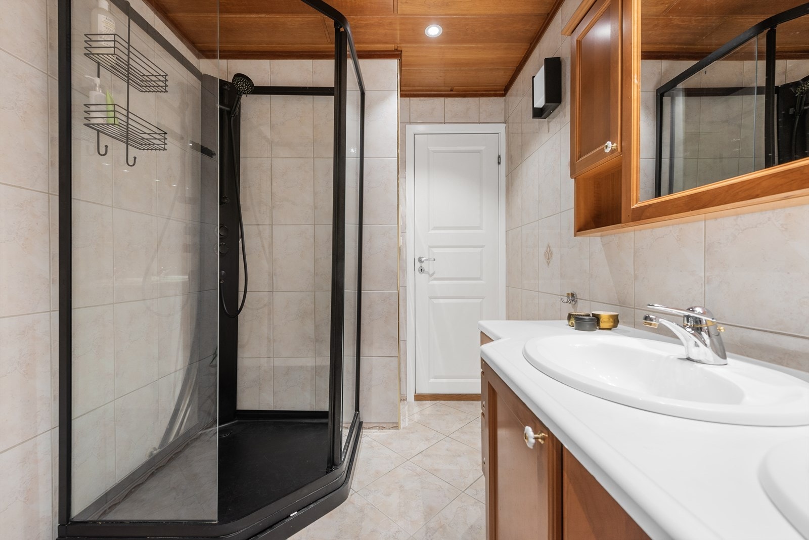 Badet på 5,6 m² har klassiske fliser på gulv og vegger, med plater og downlights i himling. Galleribilde