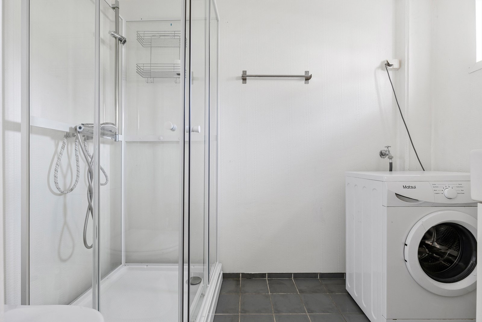 Badet er på 3,5 m² med fliser på gulv og våtromstapet på vegger. Rommet er utstyrt med dusjkabinett, mekanisk avtrekk, opplegg for vaskemaskin, servantskap klosett, og varme i gulv. Galleribilde