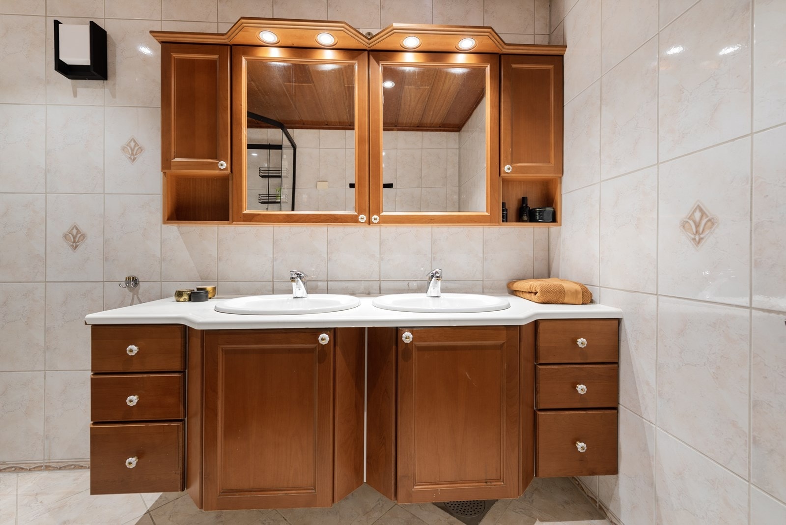 Rommet er utstyrt med dobbel servant, praktisk dusjkabinett, mekanisk avtrekk, og varmekabler i gulv. Galleribilde