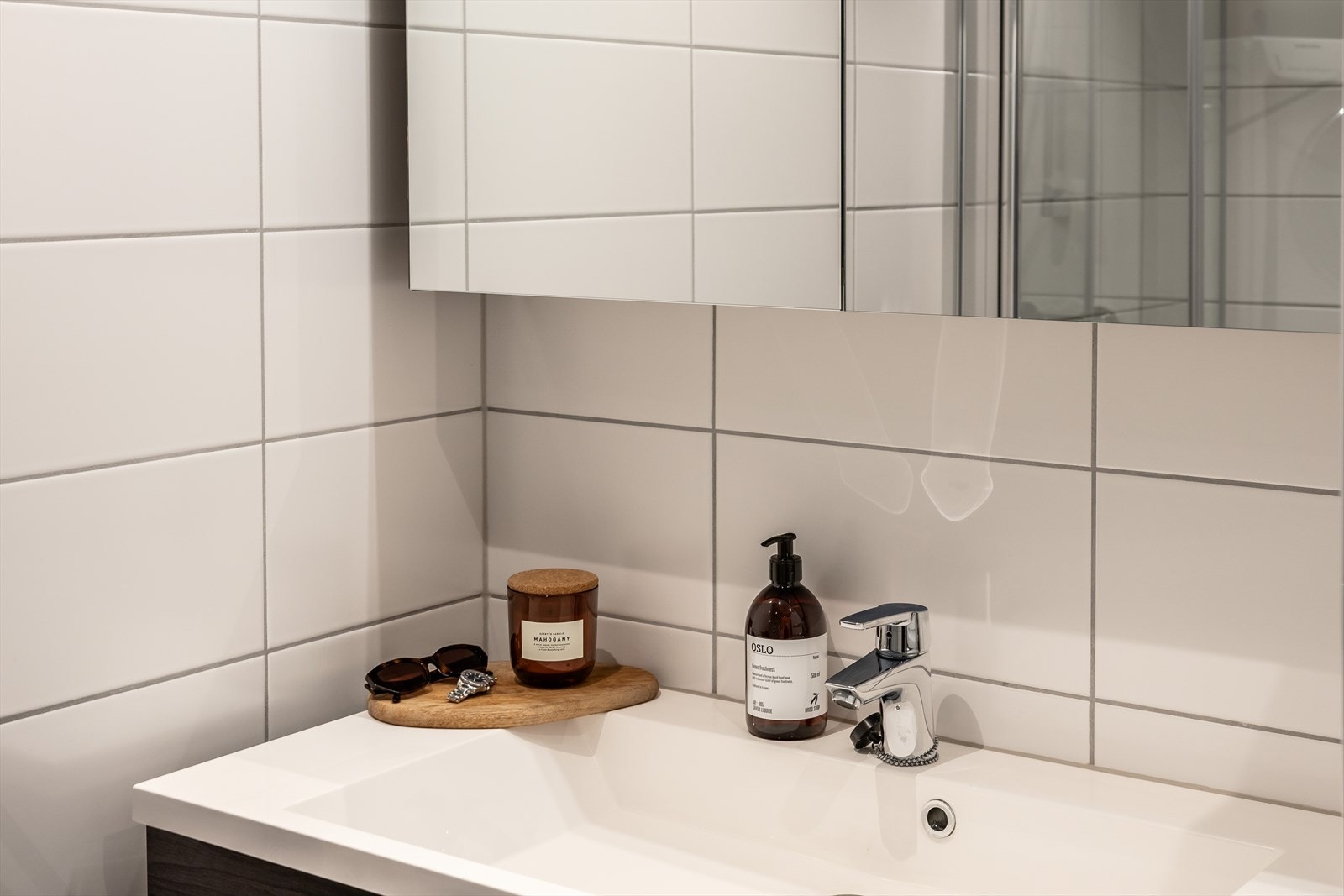 Baderomsinnredning bestående av benkeskap glatte fronter og veggskap med belysning og
speilfronter. Galleribilde