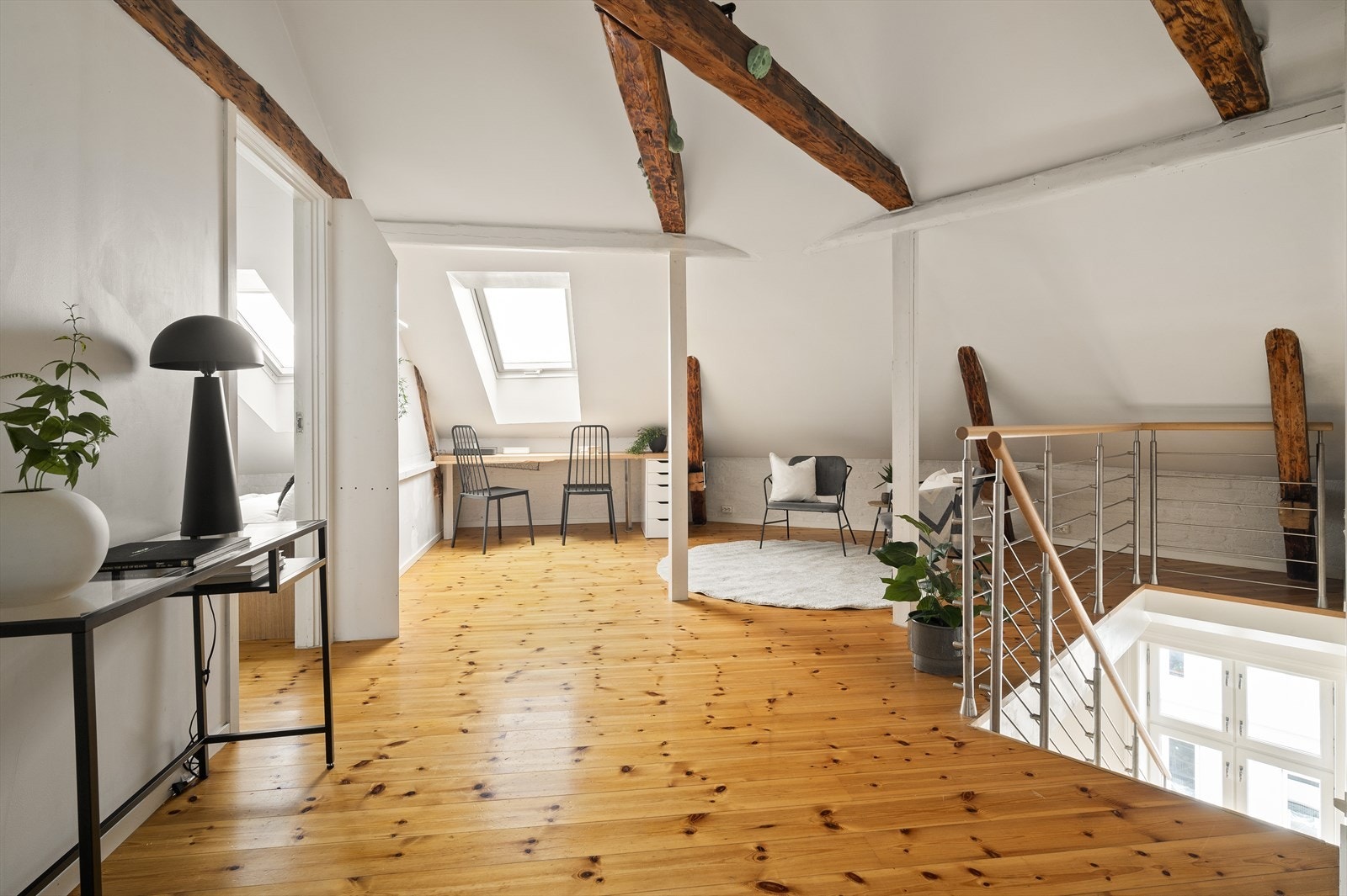 I loftsetasjen har man enda en stue med gjennomgående synlige trebjelker i hele allrommet. Galleribilde