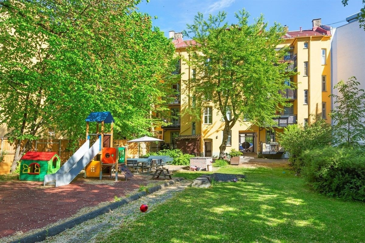 Frodig, flott opparbeidet og skjermet bakgård med beplantning, lekeplass, utegrill og sittemøblement. Galleribilde