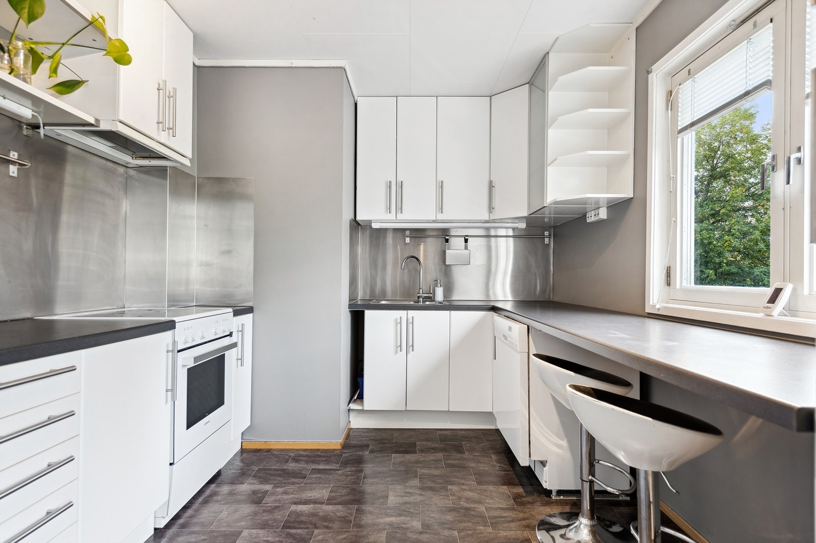 Kjøkkenet er med innredning med laminerte skrog, glatte fronter og laminert benkeplate med kjøkkenkum. Galleribilde