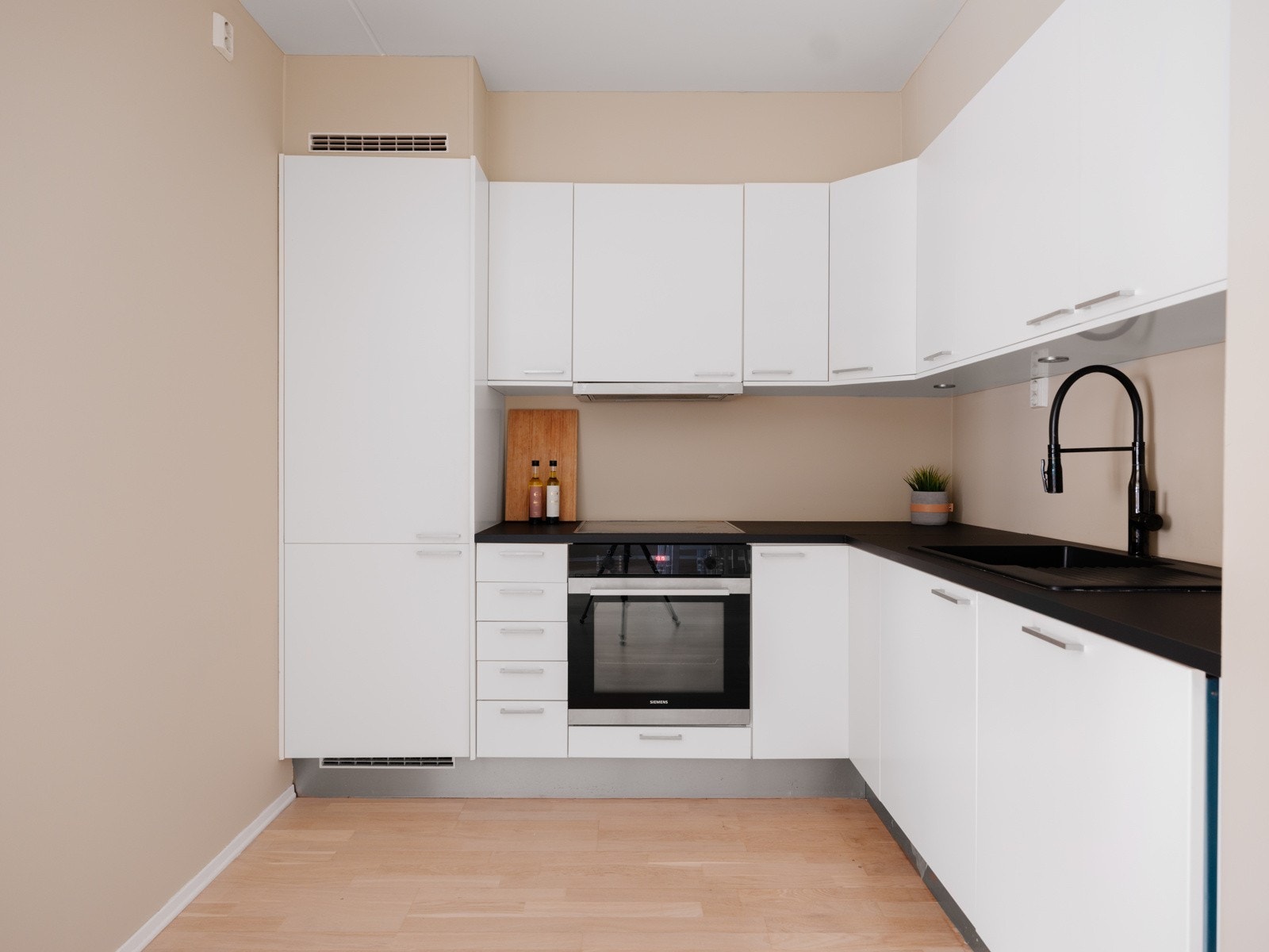 Her finnes integrerte hvitevarer som oppvaskmaskin, stekeovn, induksjon koketopp og kjøleskap med frysedel. Galleribilde