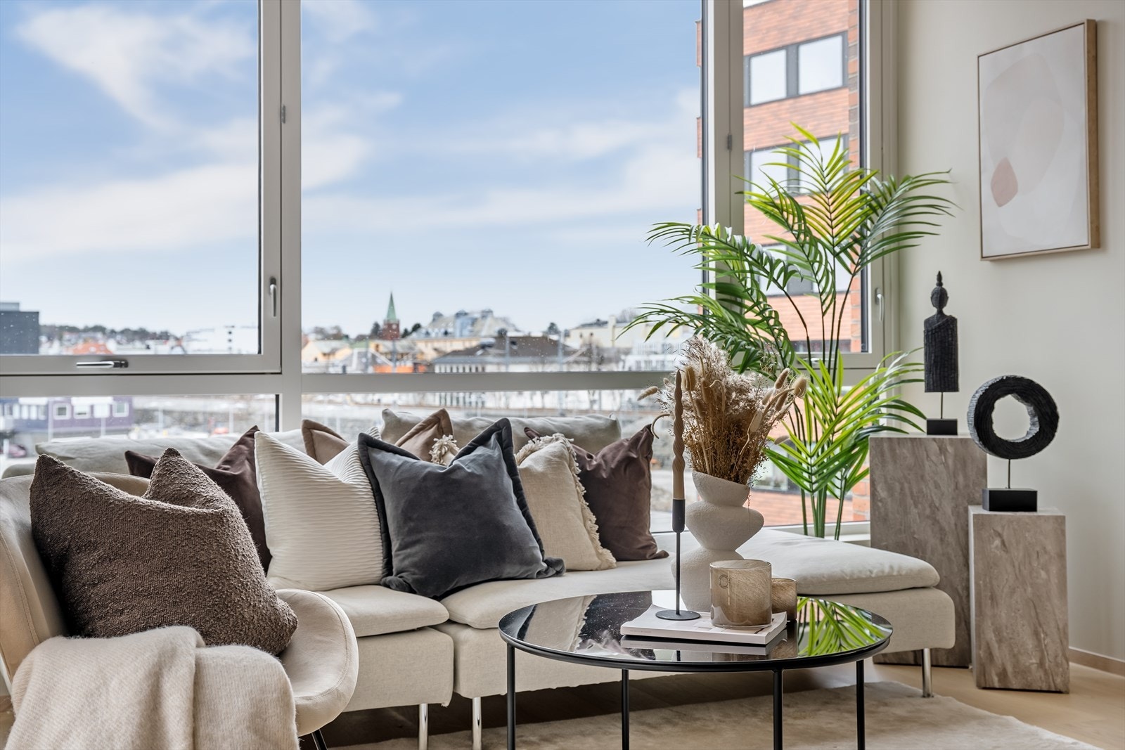 Lys og moderne stue med stor vindusflate med utsikt mot Sendnes Sentrum. Galleribilde