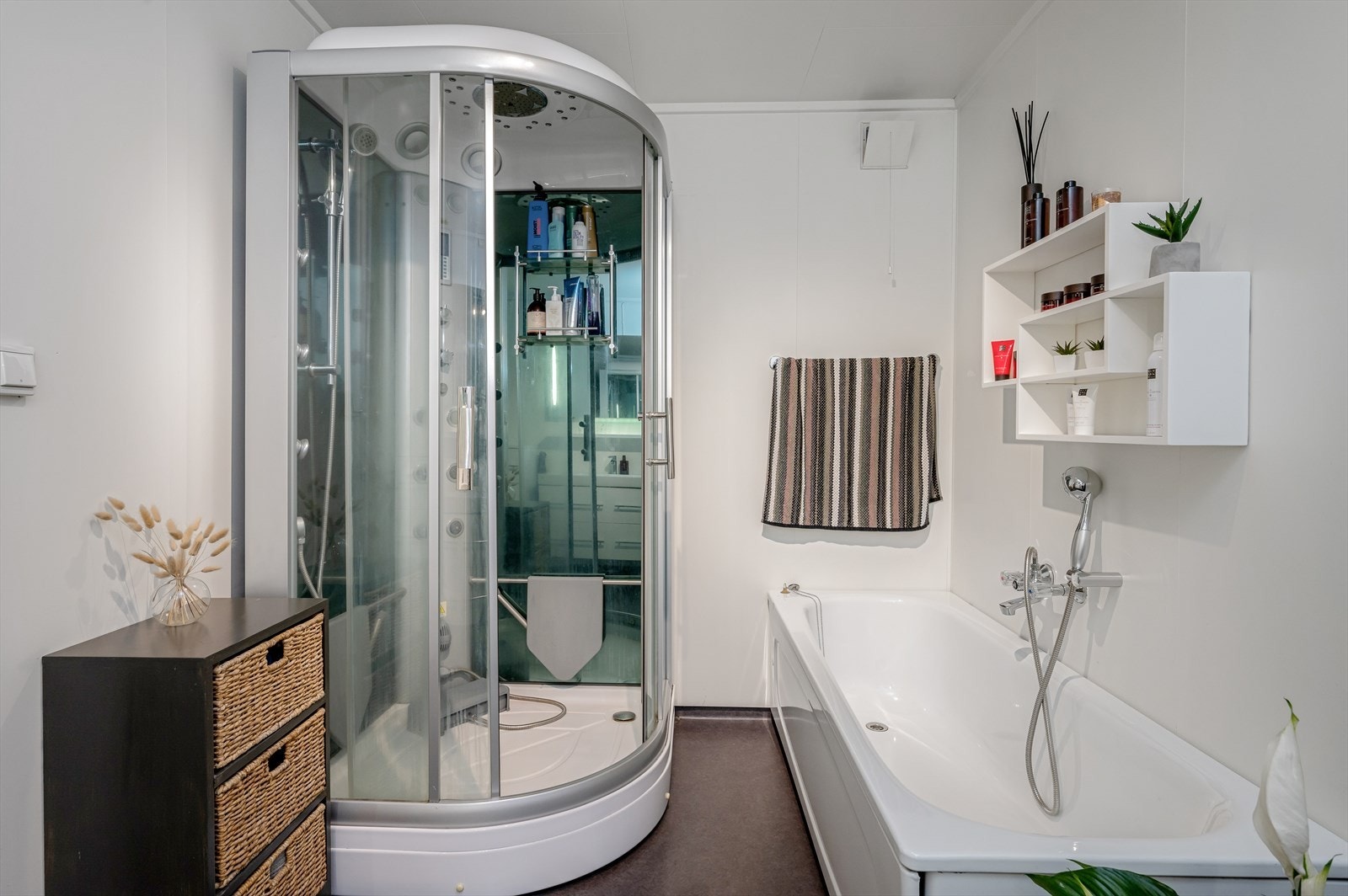 Badet har dusjkabinett med steamdusj, badekar, wc og innredning med servant. Galleribilde