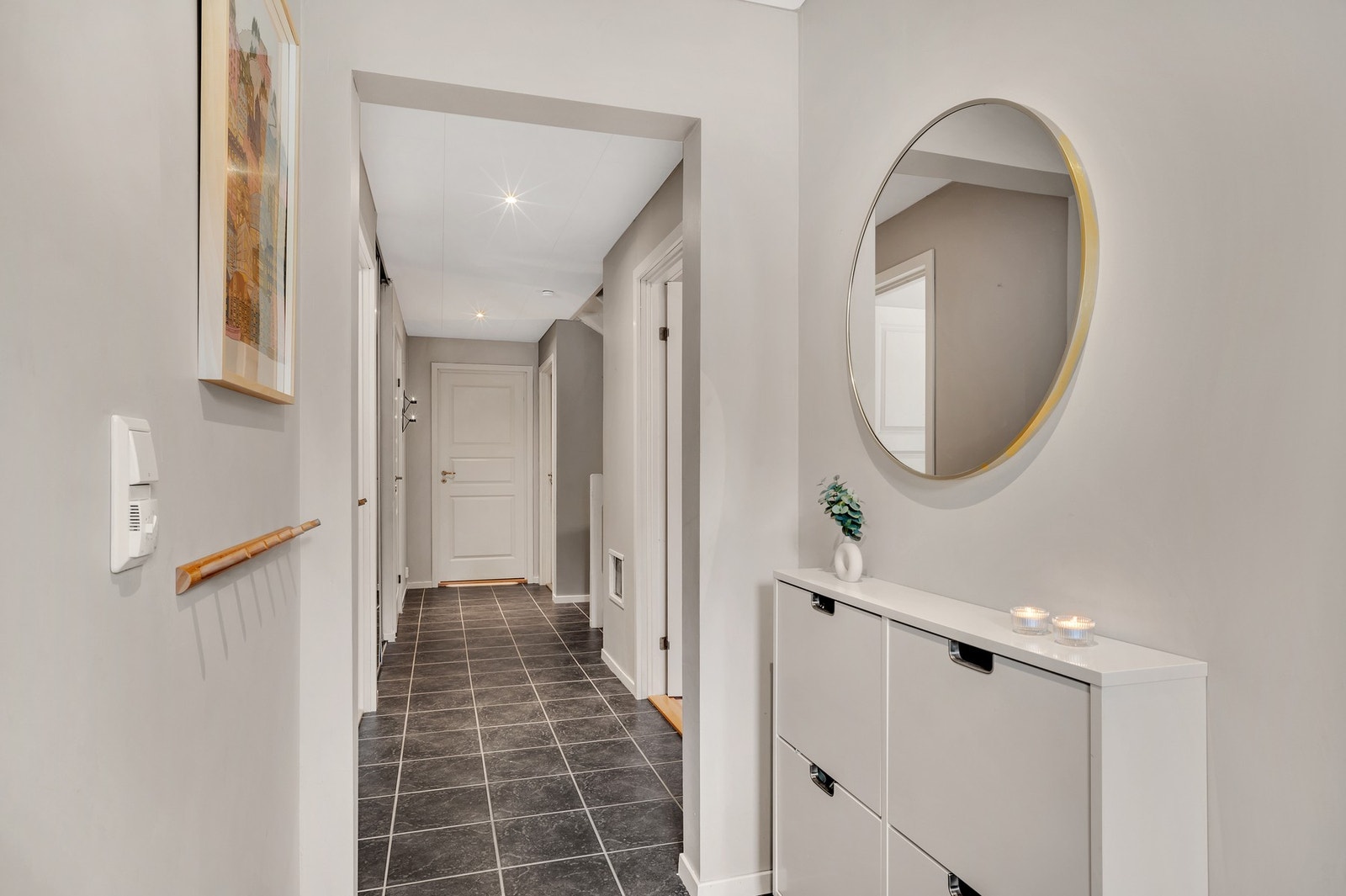 Romslig gang/vindfang på 15,5 kvm. Gangen er flislagt med varmekabler i gulv og god belysning fra downlights i tak. Galleribilde