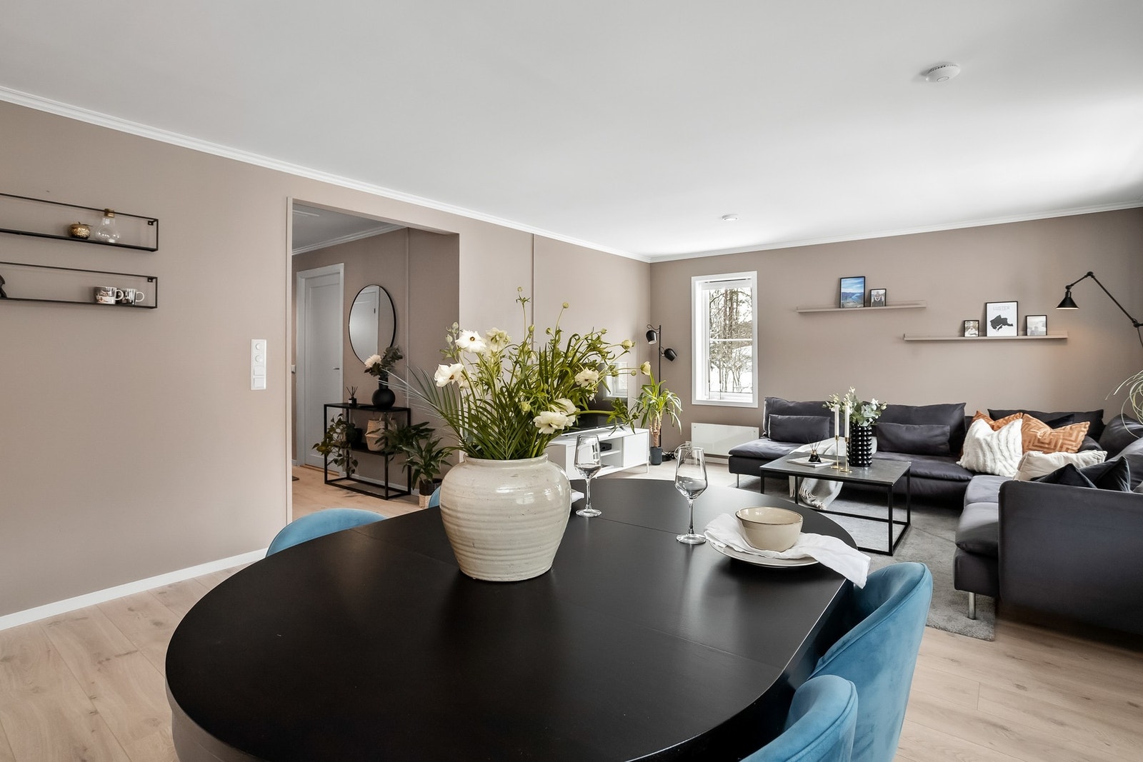 Stue og kjøkken i åpen løsning med store vindusflater som gir godt med naturlig lys. Galleribilde