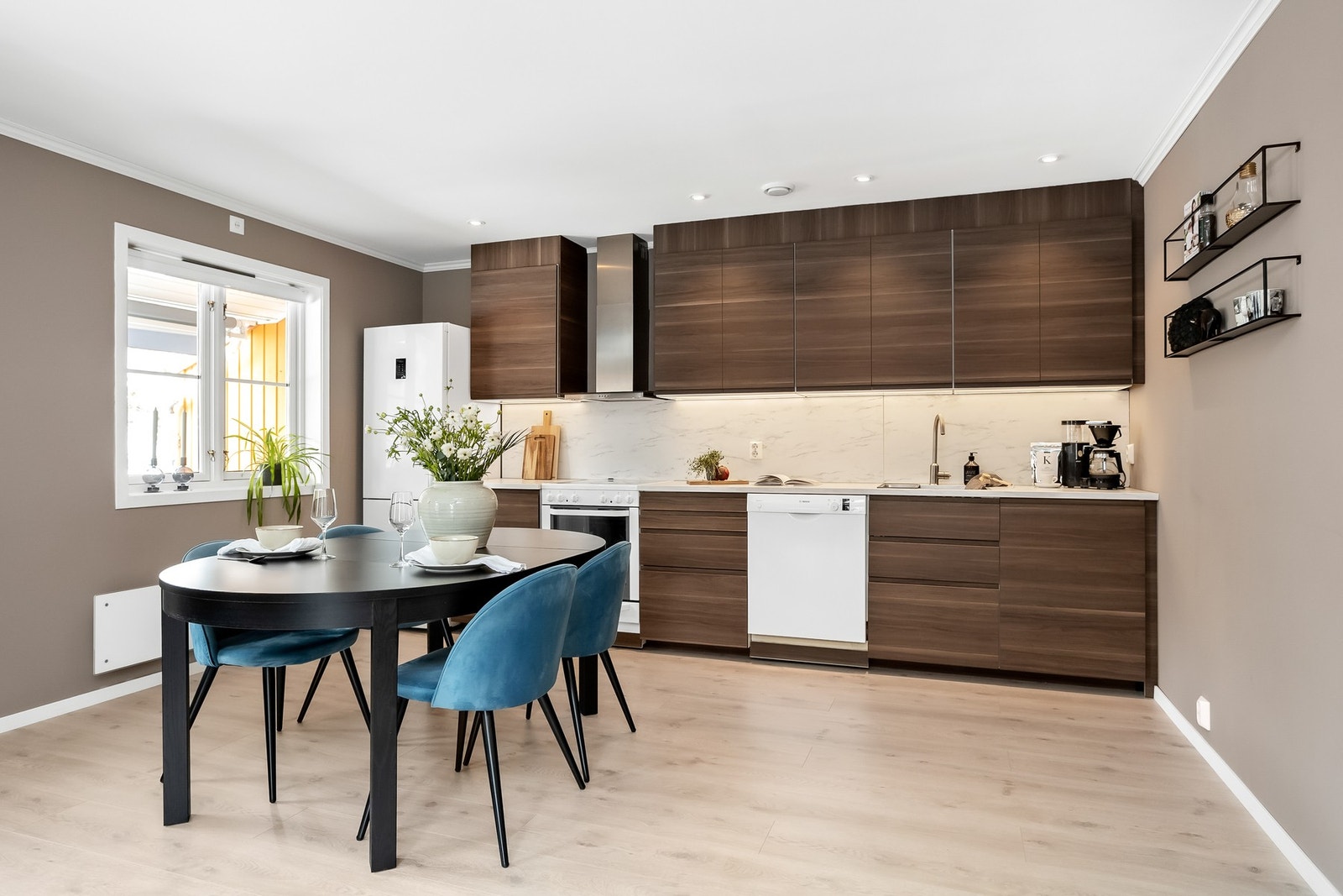 Kjøkkeninnredning med slette fronter, laminat benkeplate med vannfaste plater over benk. Galleribilde