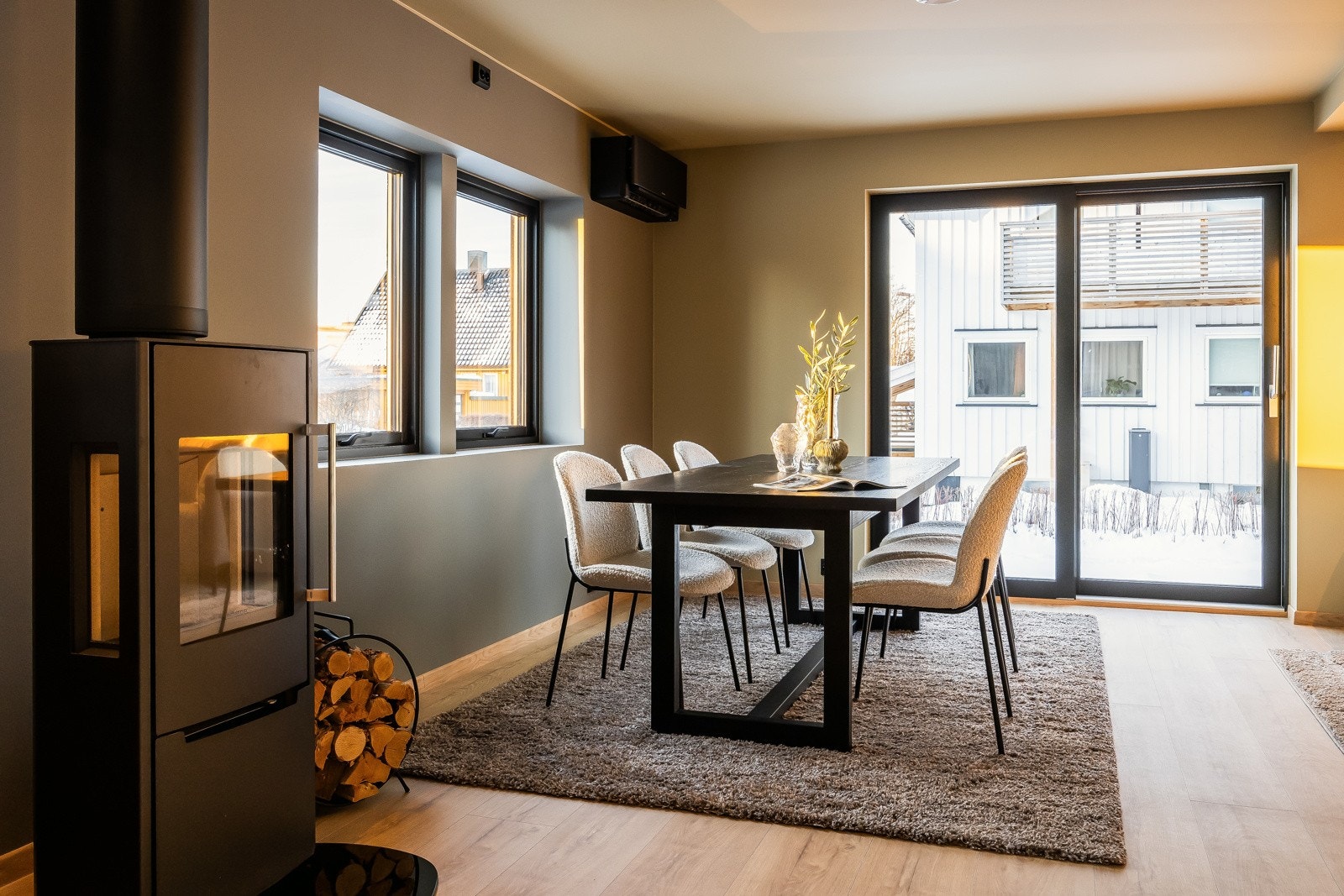 I overgangen mellom stuen og kjøkkenet er det montert en flott vedovn som i tillegg til å varme opp boligen godt også er er flott møbel Galleribilde