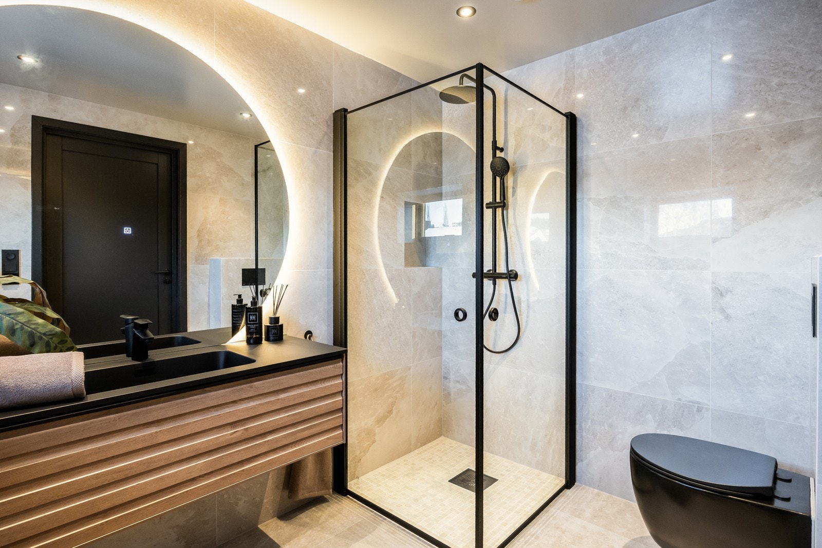 Badet gir en luksuriøs følelse med moderne farge og materialvalg i tillegg til en moderne belysning med downlights og speil med integrert lys, samt behagelige varmekabler i gulv Galleribilde