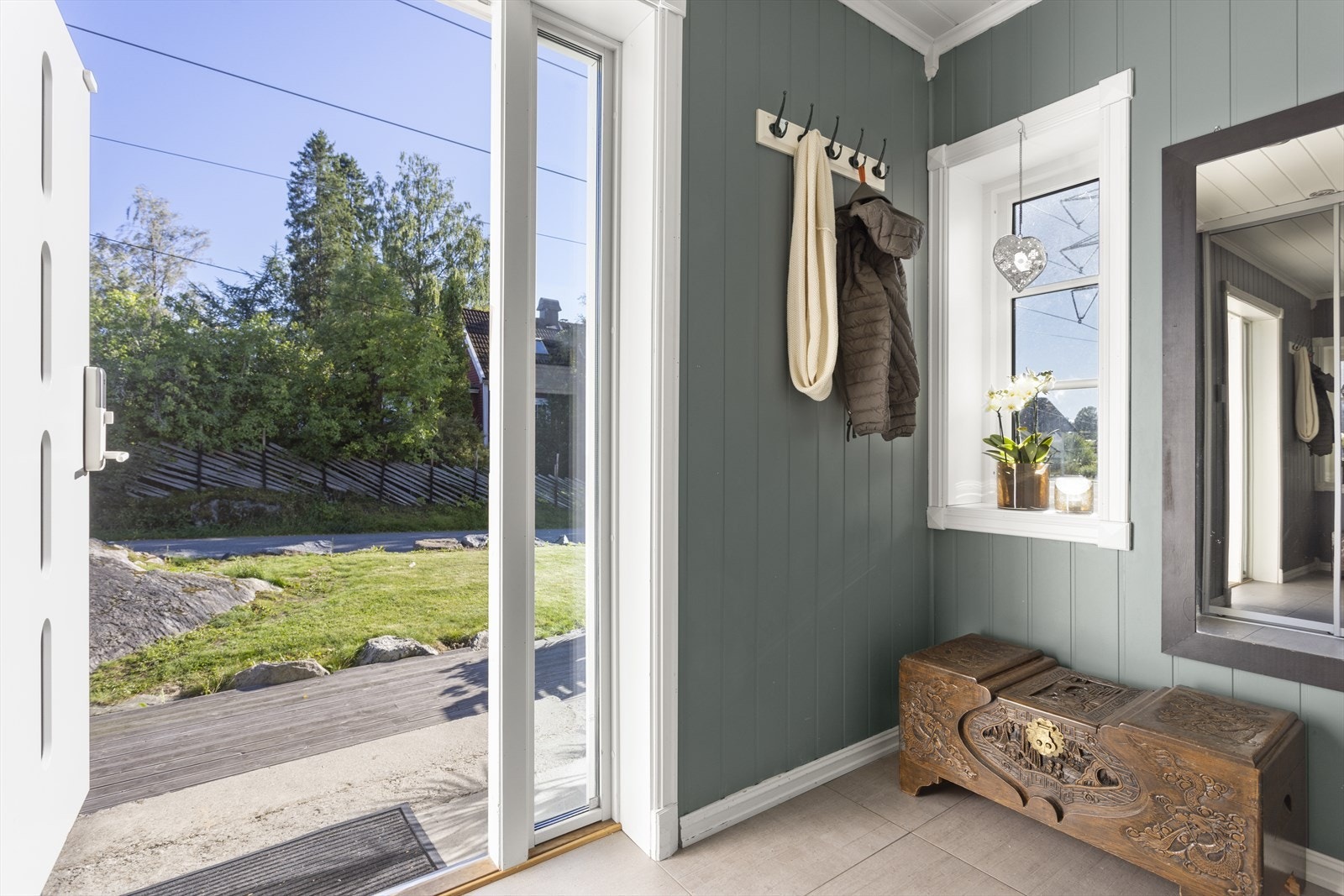 Velkommen inn! Boligen har et sjarmerende inngangsparti og vel inne i entréen er det plass til å henge fra seg yttertøy å sette fra seg sko. Gulvet er flislagt. Galleribilde