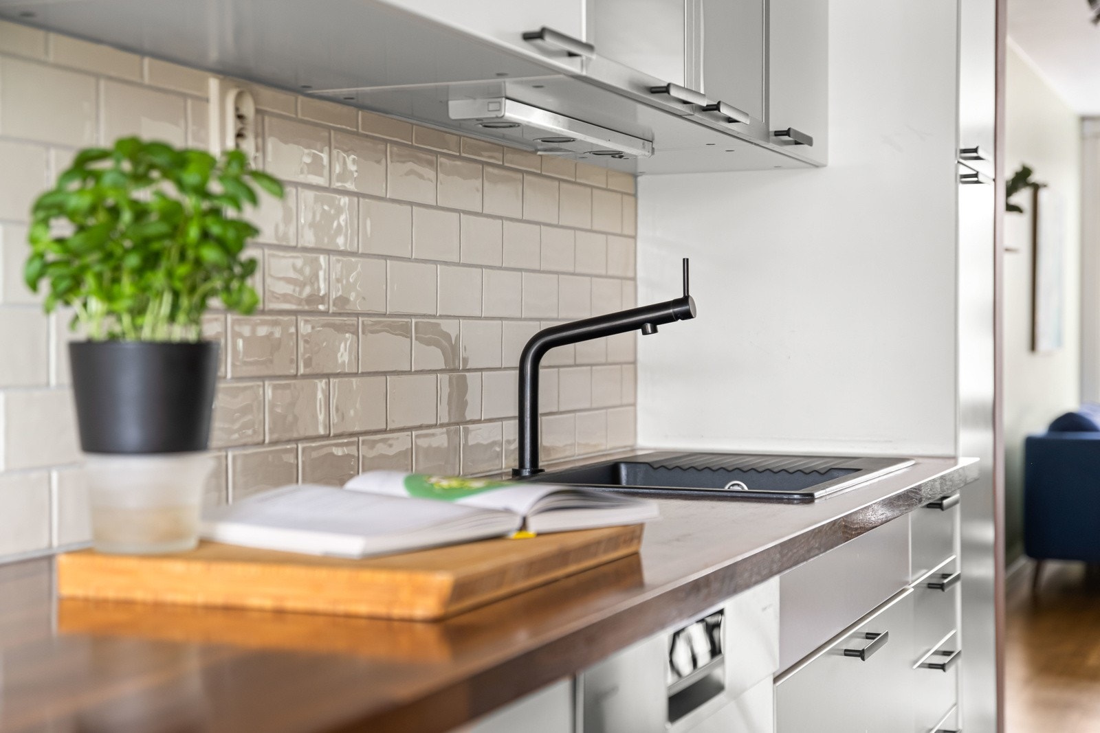 Enkelte overskap er i glass og har innlagt belysning under. Mellom benkeplaten og overskapene er det fliser Galleribilde