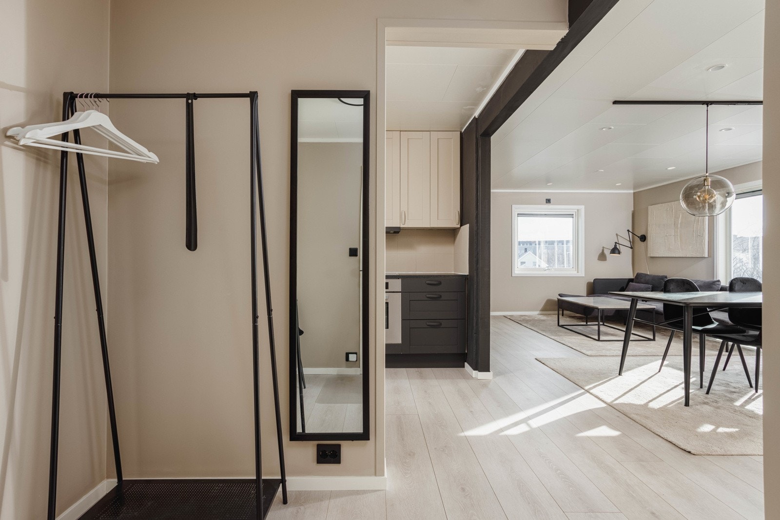 Inngangsparti som tar deg inn i en moderne gang med plass til møblement for yttertøy. Galleribilde