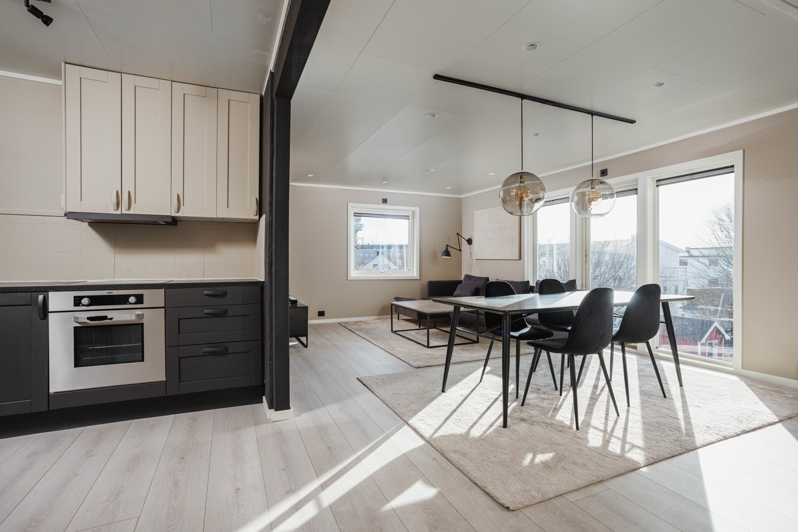 Fra gangens åpne løsning mot stuen, ser du stuen og kjøkkenets moderne fargevalg. Galleribilde