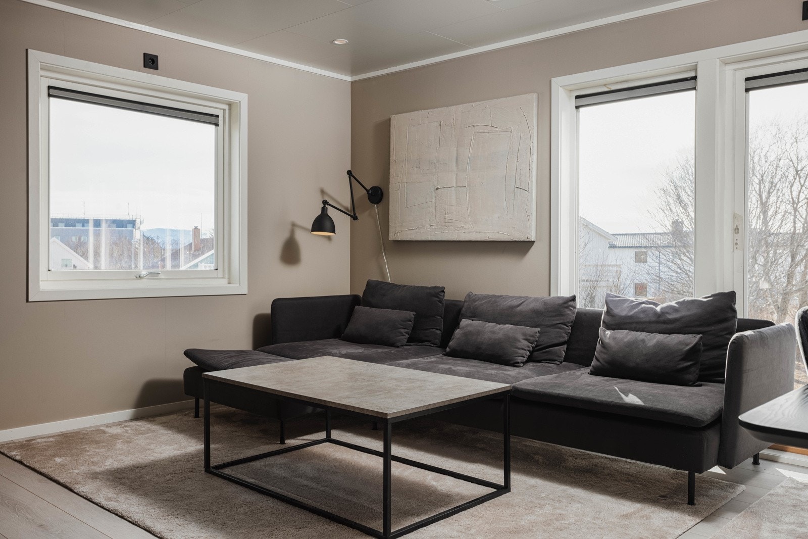 Beigemalte vegger med sorte detaljer viser leilighetens moderne preg. Galleribilde