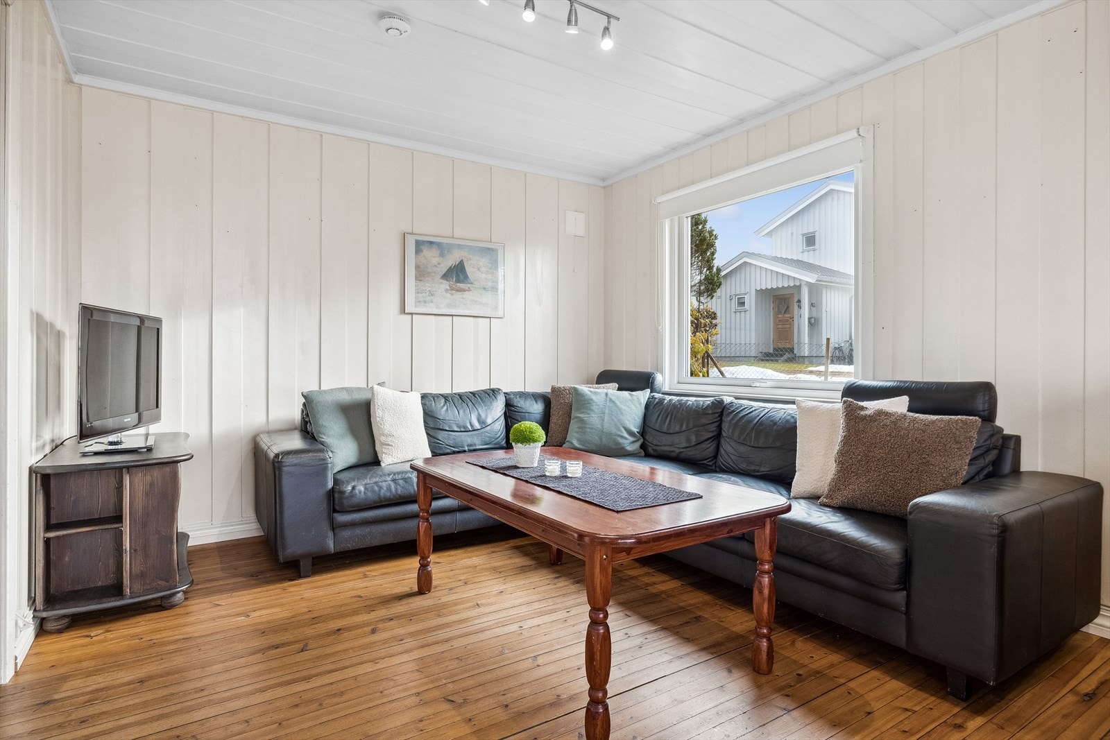 Stuen er malt i lyse farger og har olja gulvbord på gulv. Galleribilde