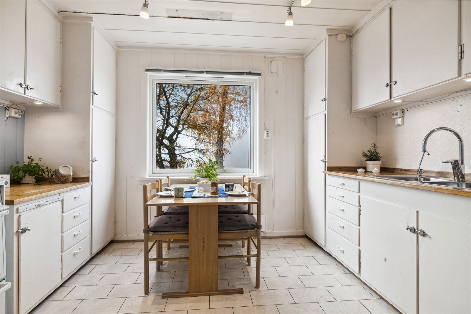 Kjøkkenet har innredning med malte, slette fronter og heltre benkeplate med nedfelt oppvaskkum i stål. Galleribilde