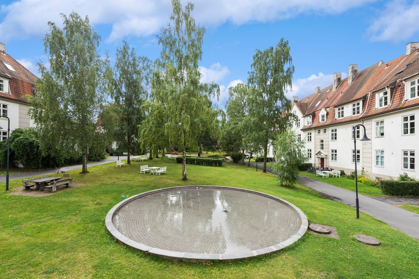 Bakgården er en grønn oase omkranset av vakre bygninger og skjermet for trafikk. Vannspeilet er de minste barnas favorittbadeplass. Galleribilde