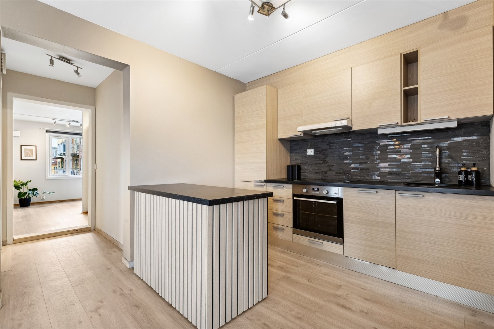 Et moderne kjøkken med stilige detaljer, folierte skrog med slette fronter og en holdbar laminert benkeplate. Galleribilde