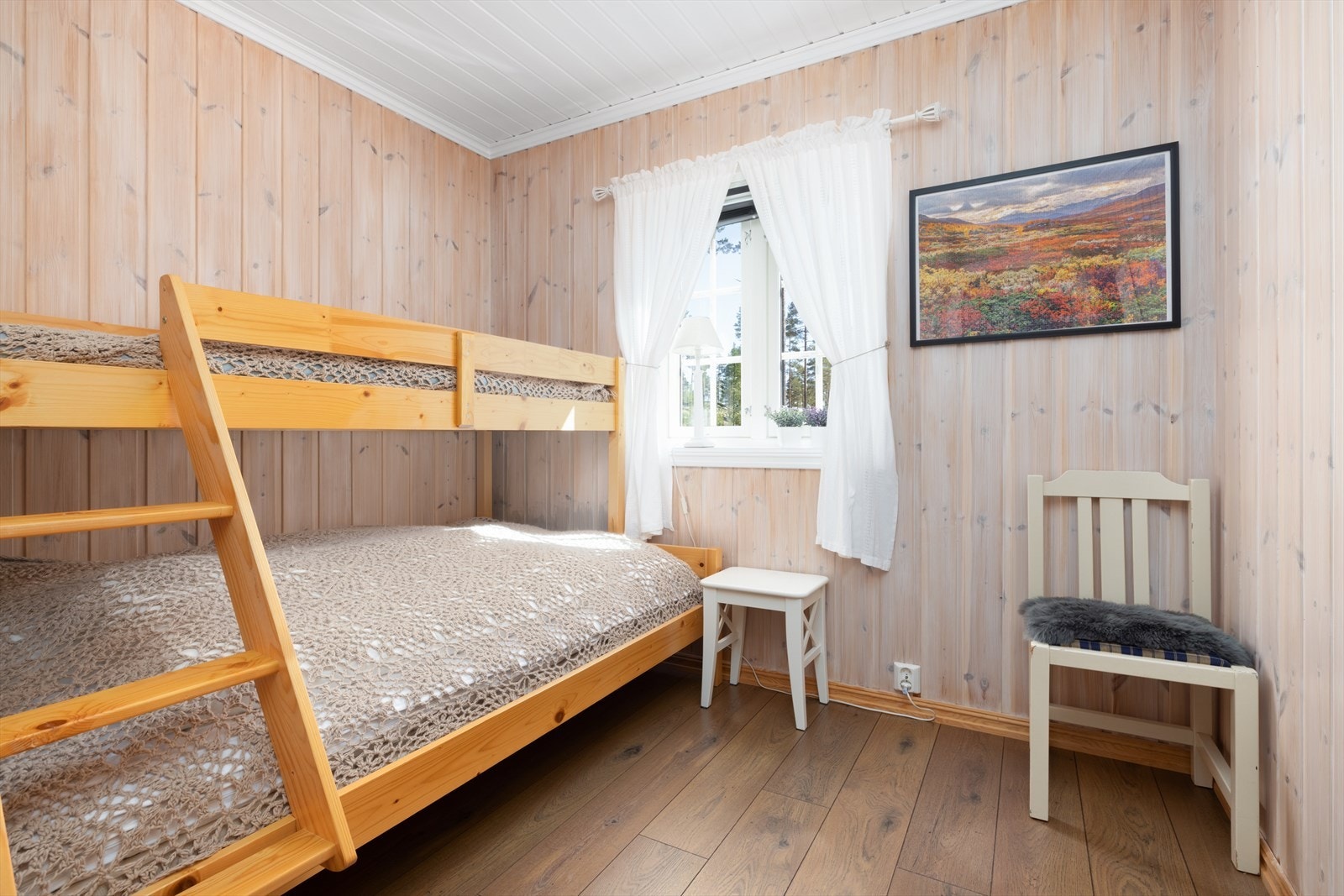 Fritidsboligen har til sammen seks soverom, her fra et av soverommene i 1.etasje. Galleribilde