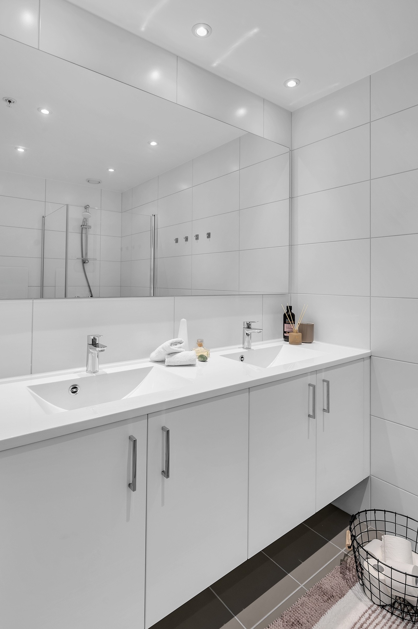 Badet har pen innredning med 2 nedfelte servanter, veggmontert toalett og dusjhjørne Galleribilde