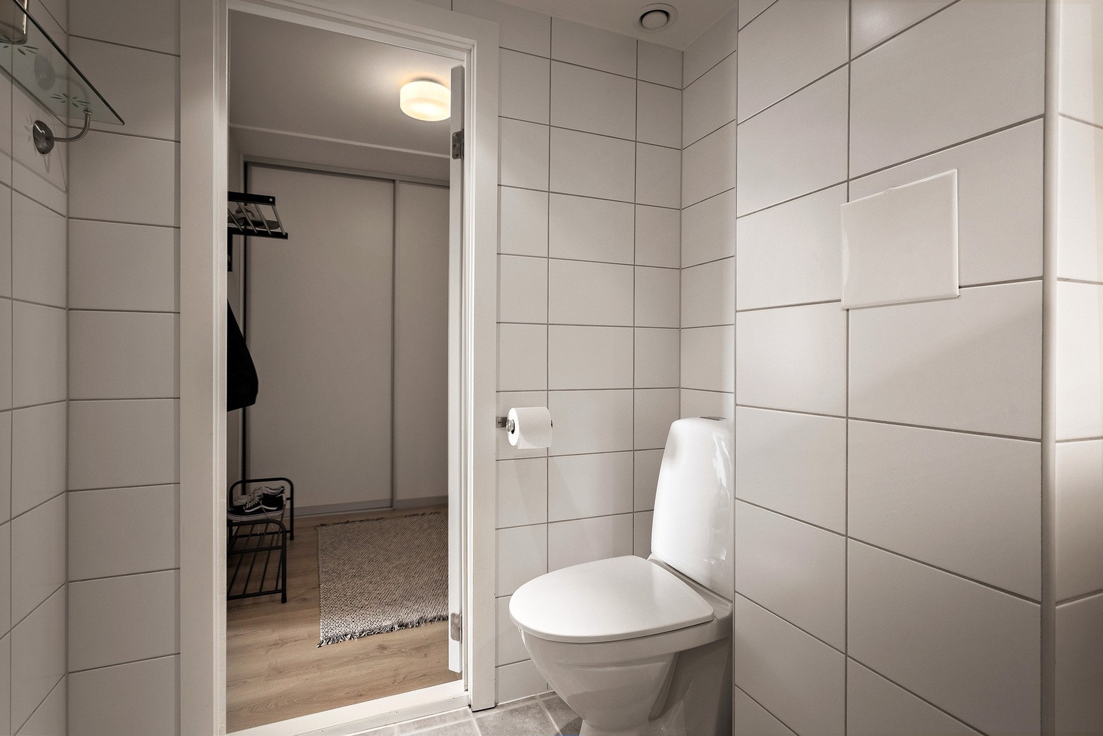 Baderomsinnredningen består av skuffeseksjon med helstøpt servant samt speilskap på overside. Videre er det gulvstående toalett og dusjhjørne med skyvedører. Galleribilde