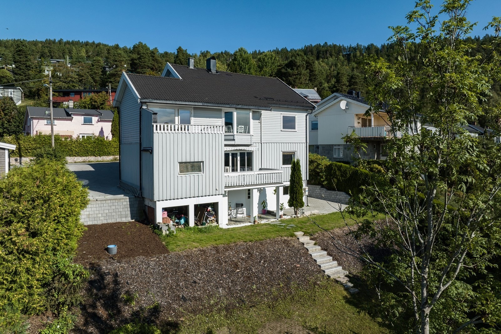 Tomten er opparbeidet med hage og diverse beplantning Galleribilde