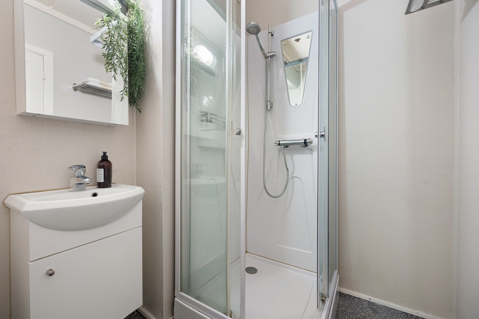 Badet er innredet med dusjkabinett, servant, møbler og wc. Galleribilde